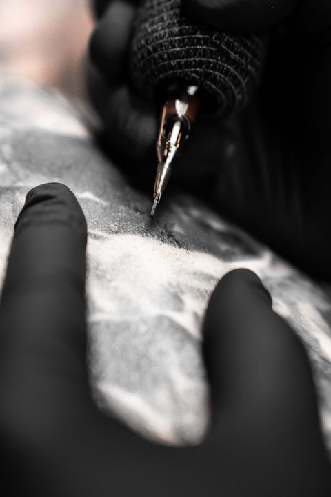 Tattoo-Nadel kurz vor der Haut, Detailaufnahme